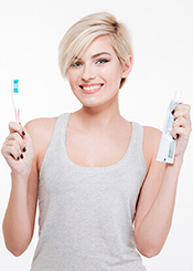 woman smiling with toothbrush and toothpaste