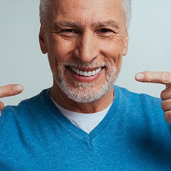 Senior man pointing at his attractive smile