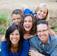 Family of five laughing and smiling in the grass