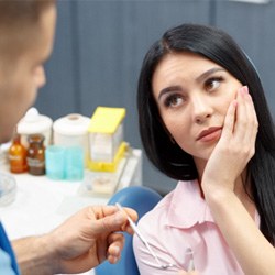 patient with tooth pain talking to dentist  