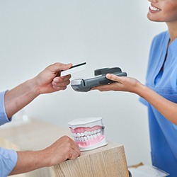 Patient paying for cosmetic dentistry in Louisville