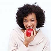 woman biting into a red apple 