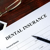 Dental insurance form on desk with pen