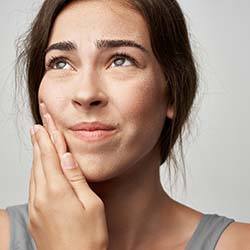 Woman with a toothache in Louisville holding her mouth