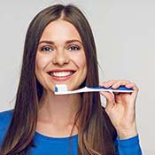 Woman holding a toothbrush and smiling