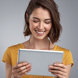 Smiling woman looking at insurance forms on tablet computer