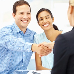 Man and woman reviewing insurance forms with dental team member