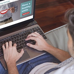 Man looking at insurance forms on laptop