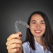 woman holding an Invisalign aligner