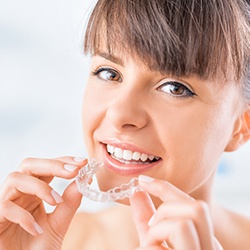 Woman placing her Invisalign tray