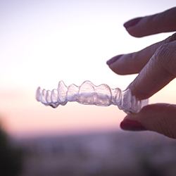 Hand holding an Invisalign tray