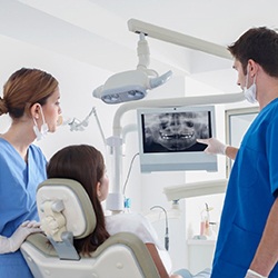 dentist showing a patient in the dental chair their x-rays