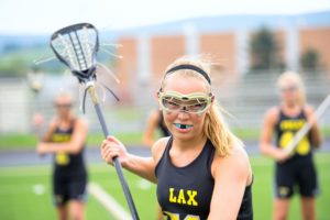 young athlete protecting her smile with a custom mouthguard 