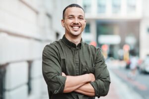 Smiling man standing with arms crossed.